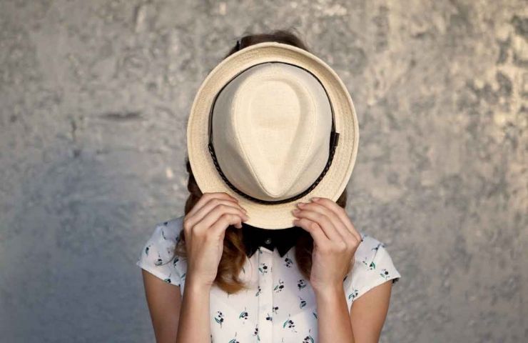 woman covering face with hat